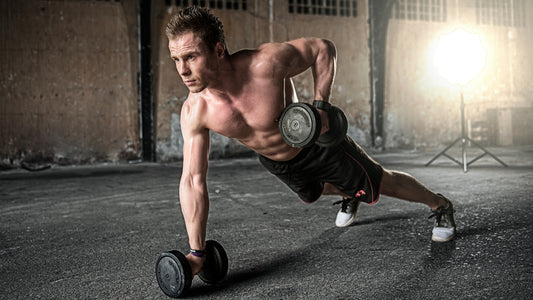 Fit man working out in the gym with dumbbell